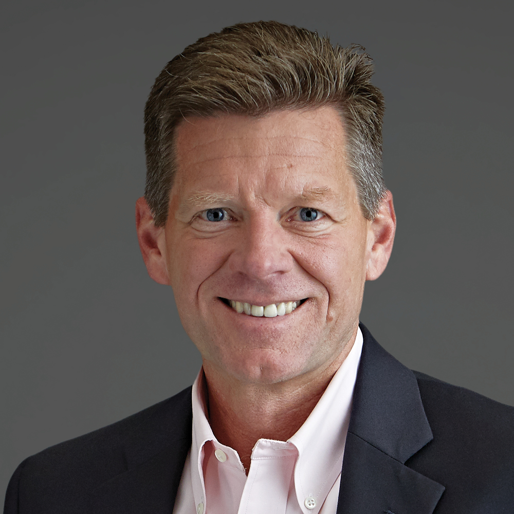 ambassador enterprises chief financial officer bob vitoux on dark gray background smiling