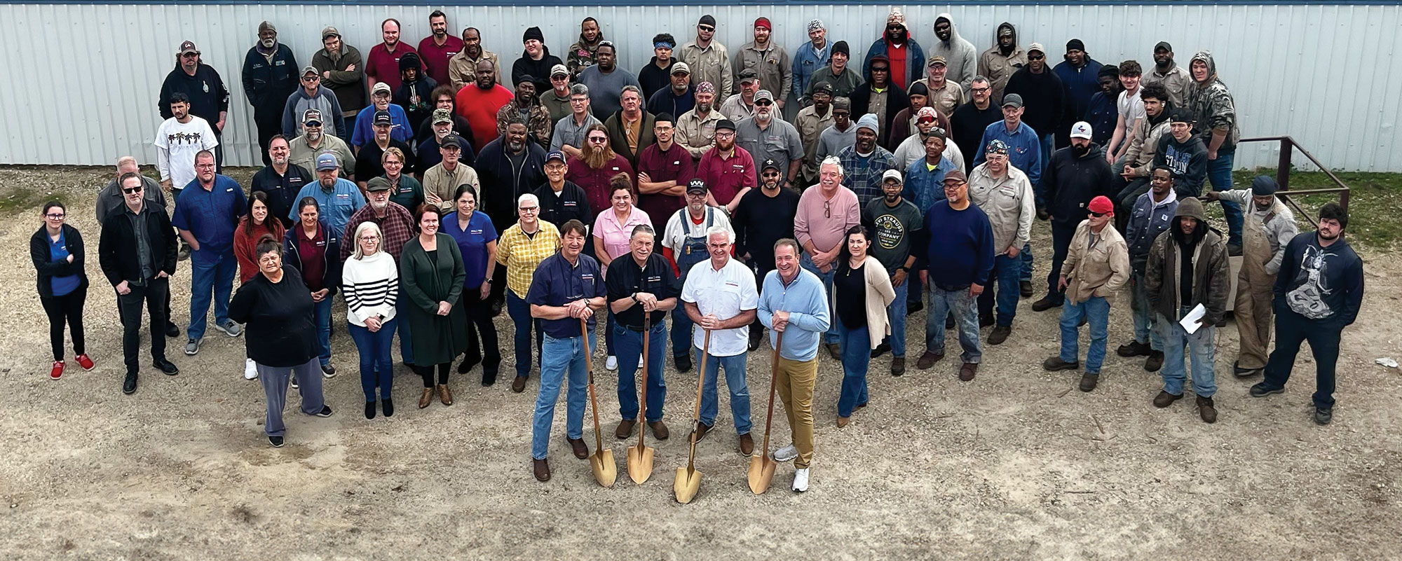ideal steel employees standing in front of metal fence