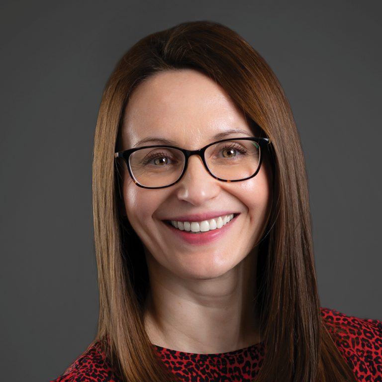 Malina Pascut on dark background smiling.