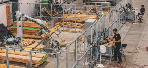 rival lab operators working with robotic arm moving lumber